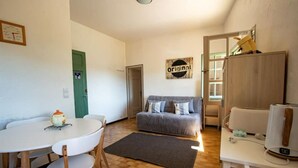 En kompakt bolig med spiseplads, sofa og tekøkken.