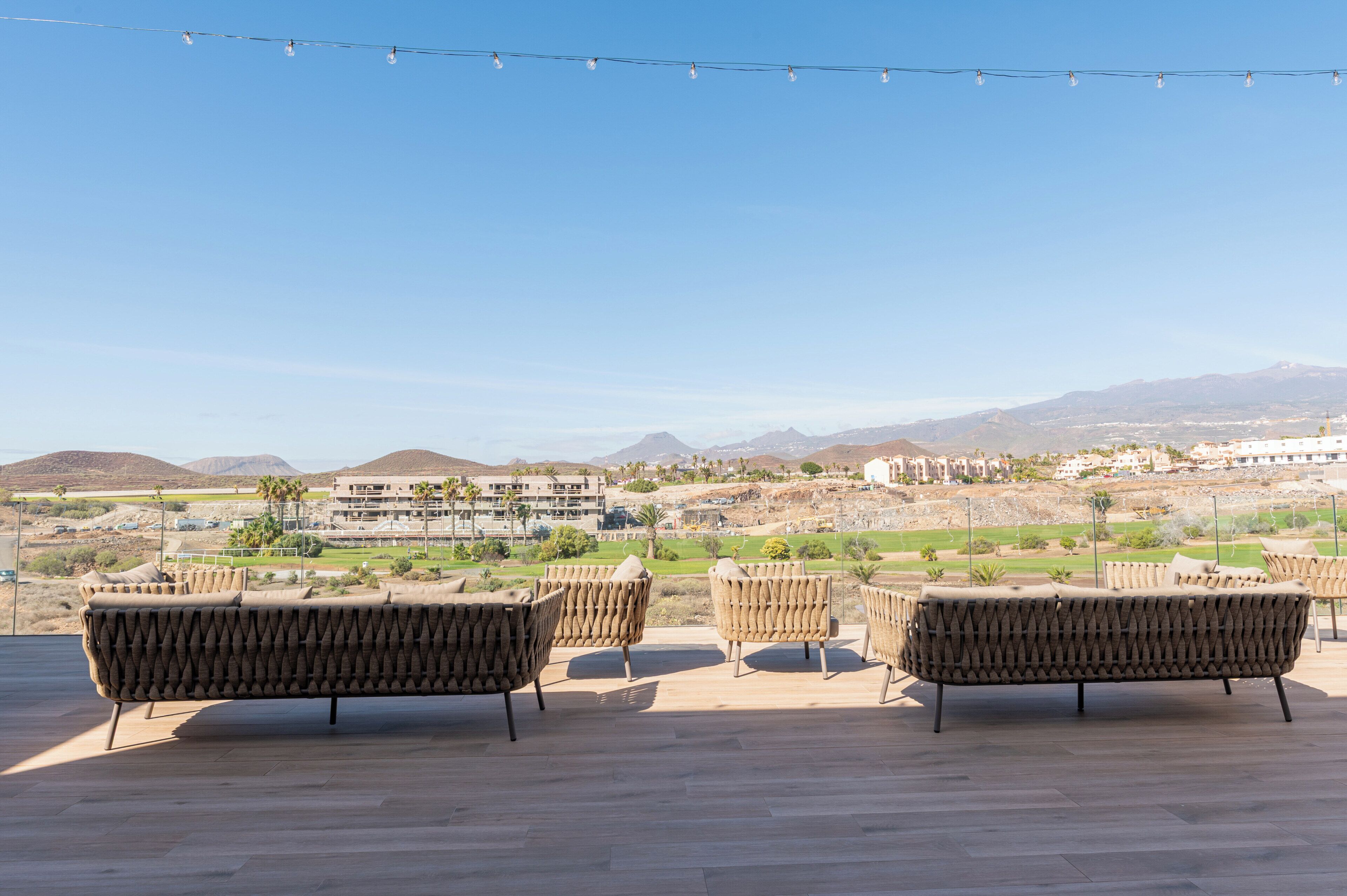 Outdoor seating with a view of a residential area and mountains.