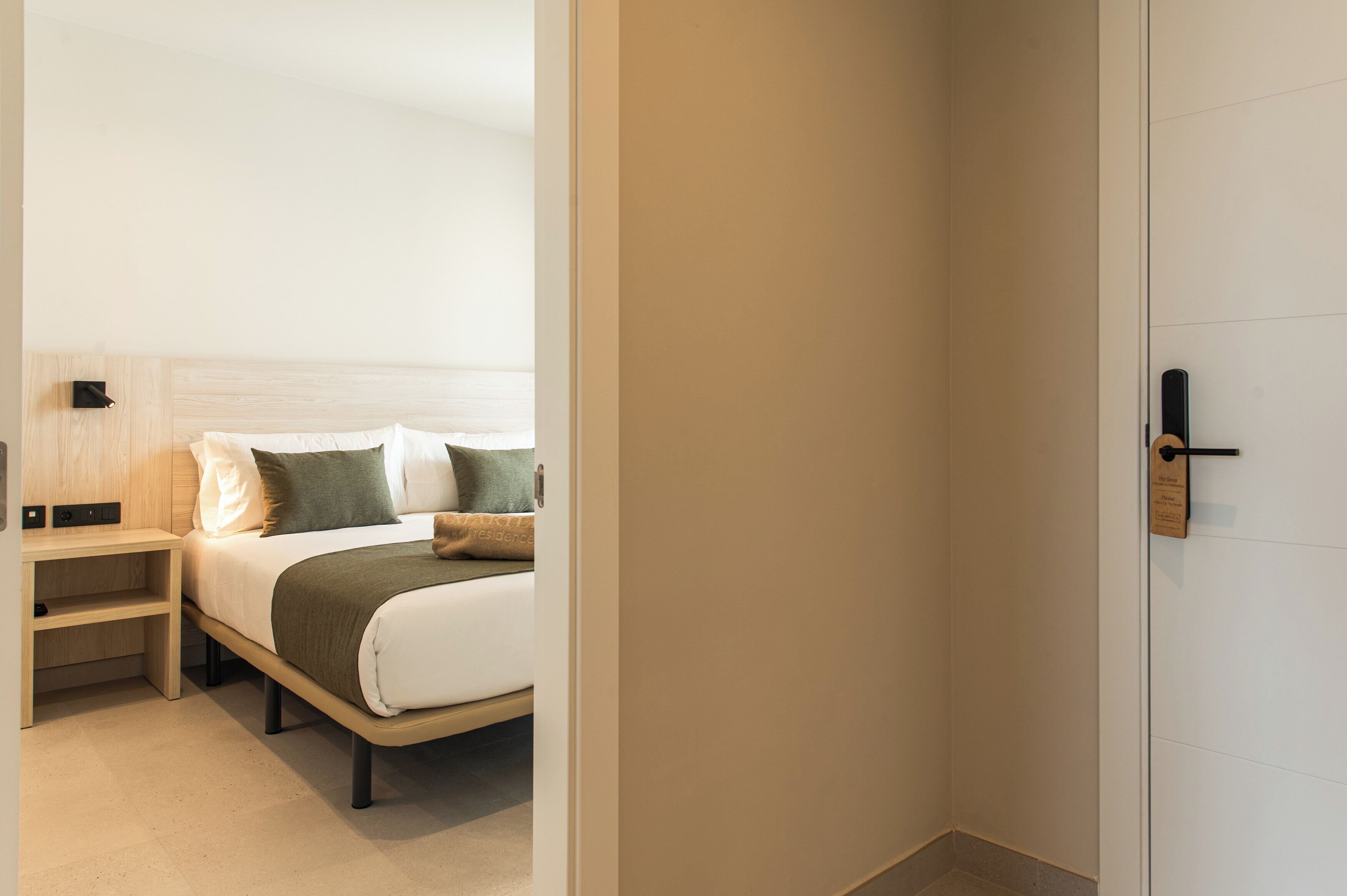 Ein modernes Hotelzimmer mit Bett, Nachttischen und einer Tür.