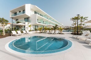 A modern hotel with a swimming pool, sun loungers, and a clear blue sky. - Amarilla Golf Residences (San Miguel de Abona)