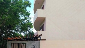 A modern building with a concrete entrance and a metal gate. - Lovely Loft In Veleta (Tulum)