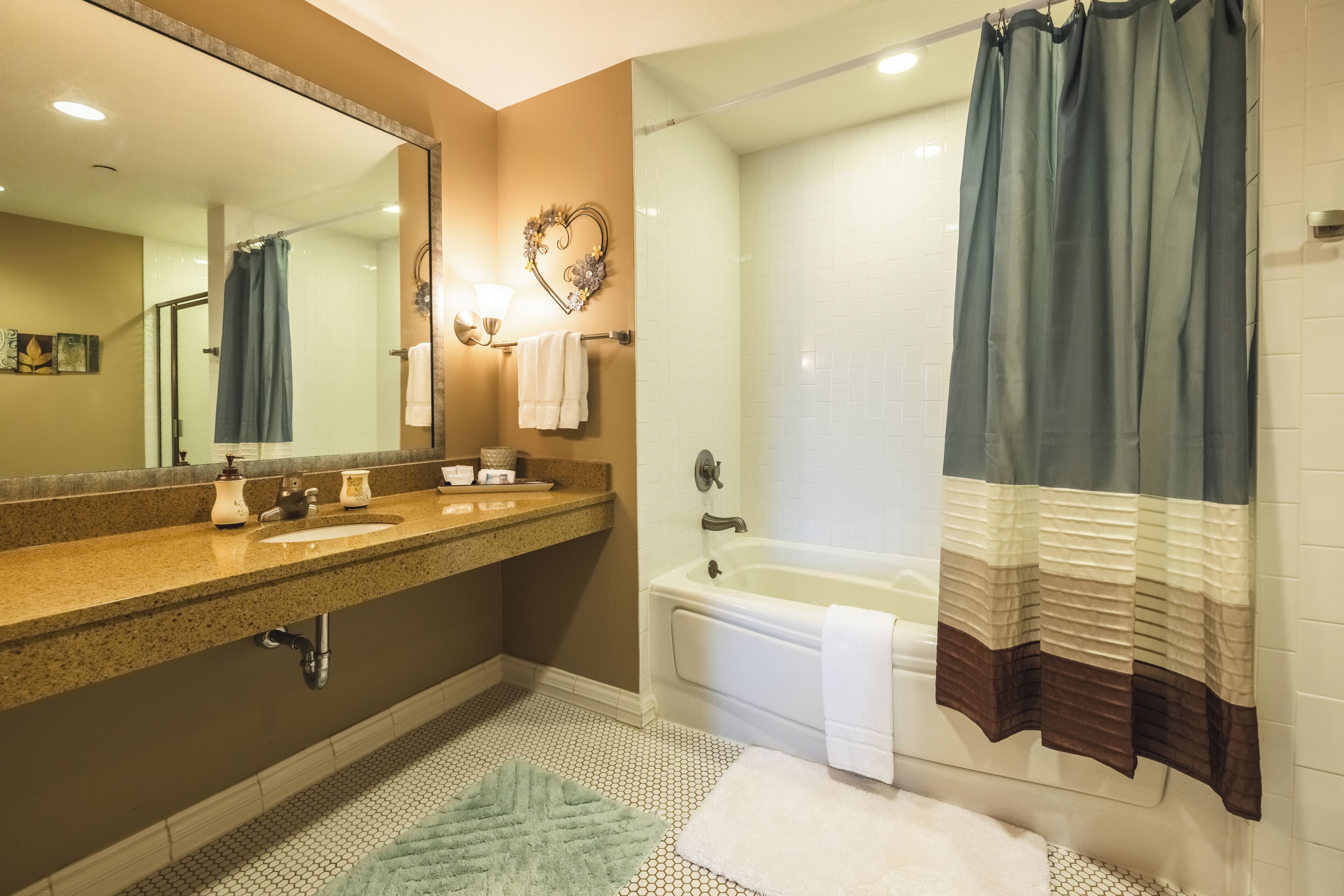 Un baño con lavamanos, espejo y bañera.