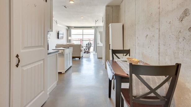 Una cocina con una mesa y sillas, un refrigerador y una ventana con vistas al exterior.