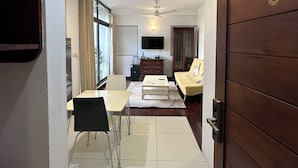 Una sala de estar moderna con comedor, televisor y ventilador de techo.