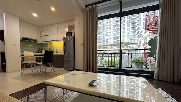 Un apartamento moderno con comedor, cocina y un amplio balcón con vistas a la ciudad.