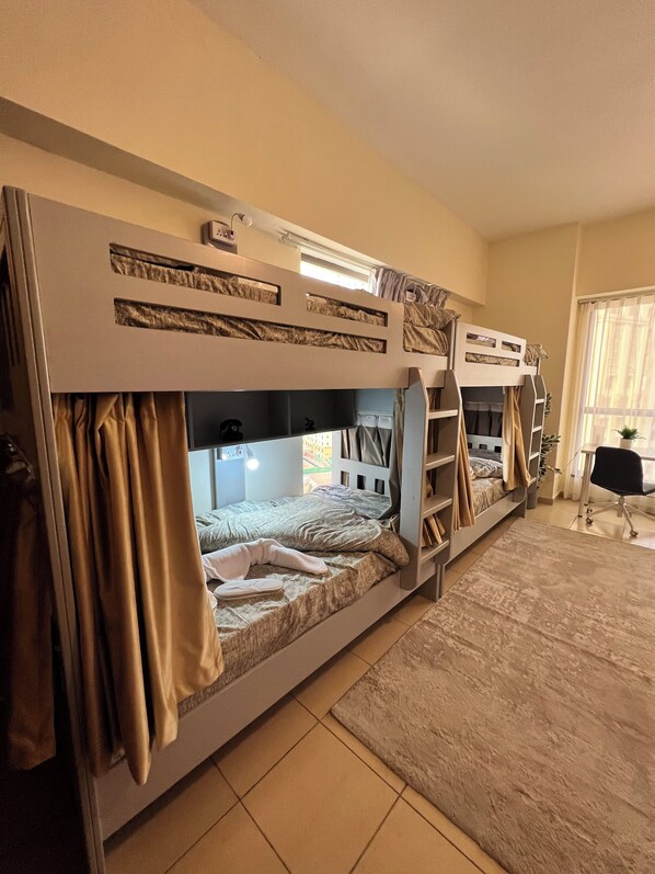Une chambre avec des lits superposés, un bureau et une chaise.