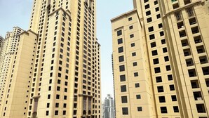 A high-rise building with multiple floors, featuring a consistent architectural style with rectangular windows and balconies. - Enjoy and Stay In Dubai Homes (Dubai)