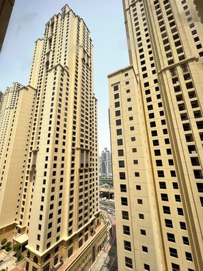 Un immeuble de grande hauteur, doté de nombreux étages, qui présente un style architectural uniforme, caractérisé par des fenêtres rectangulaires et des balcons.