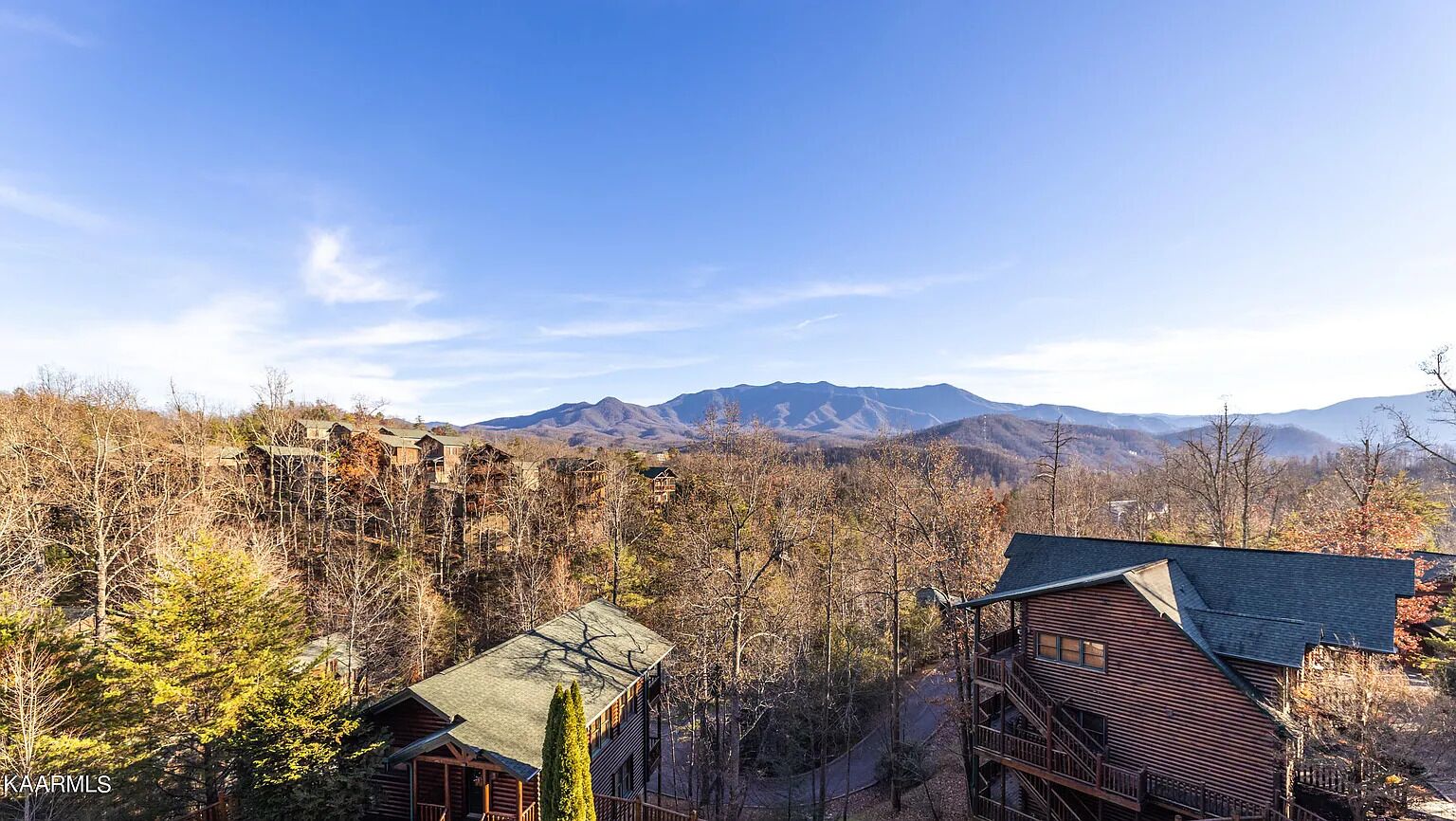 A cabin with a balcony overlooking a mountainous landscape.