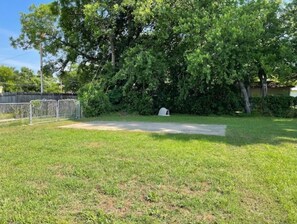 Enjoy a serene escape in a, lushly landscaped area with a grassy lawn and paved path.