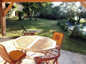 Relax in a serene outdoor space surrounded by lush greenery and a tranquil pool view.