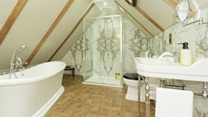 A bathroom with a freestanding bathtub, a glass-enclosed shower, a toilet, and a sink.