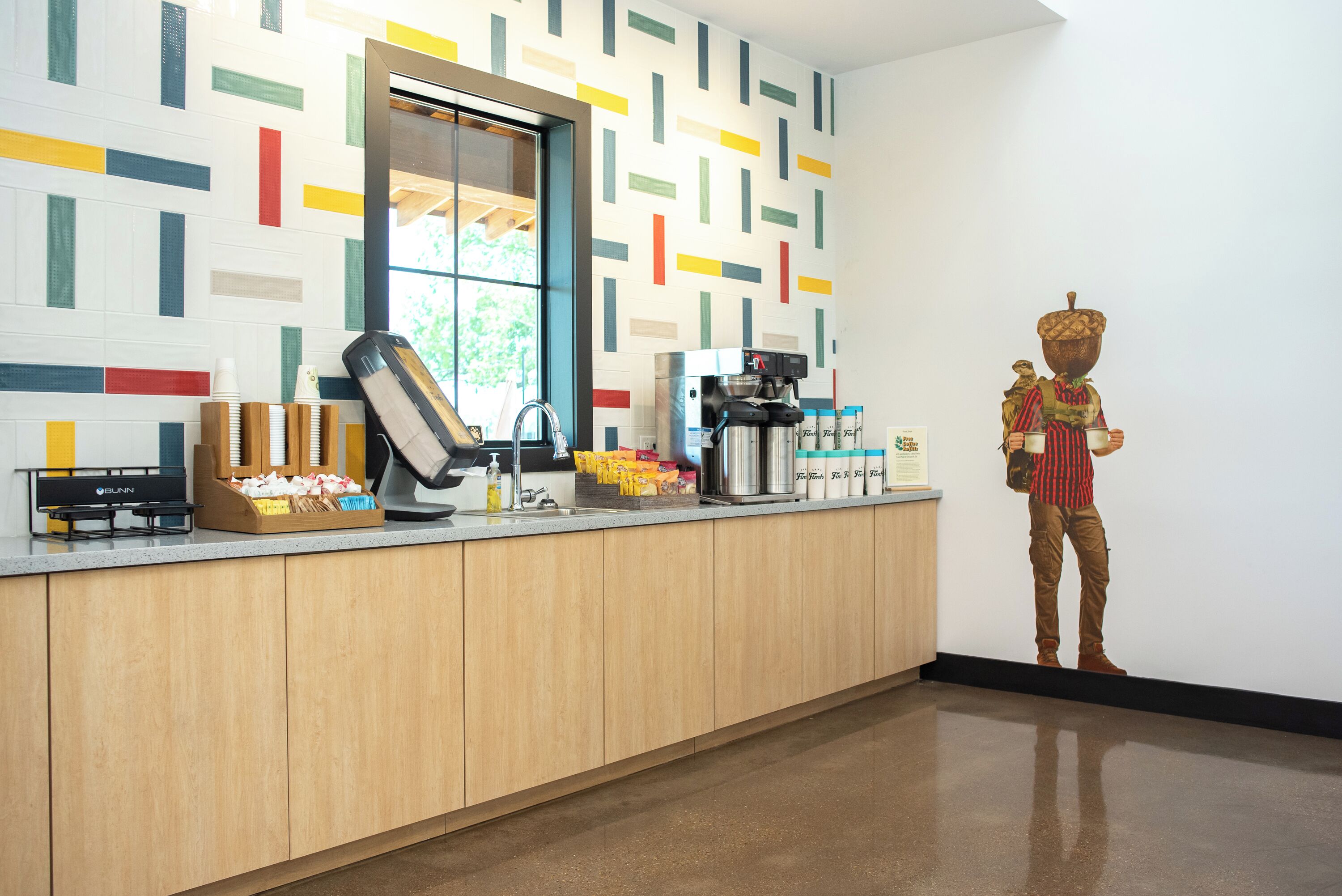 A modern kitchen with a coffee machine, a sink, and a decorative figure.