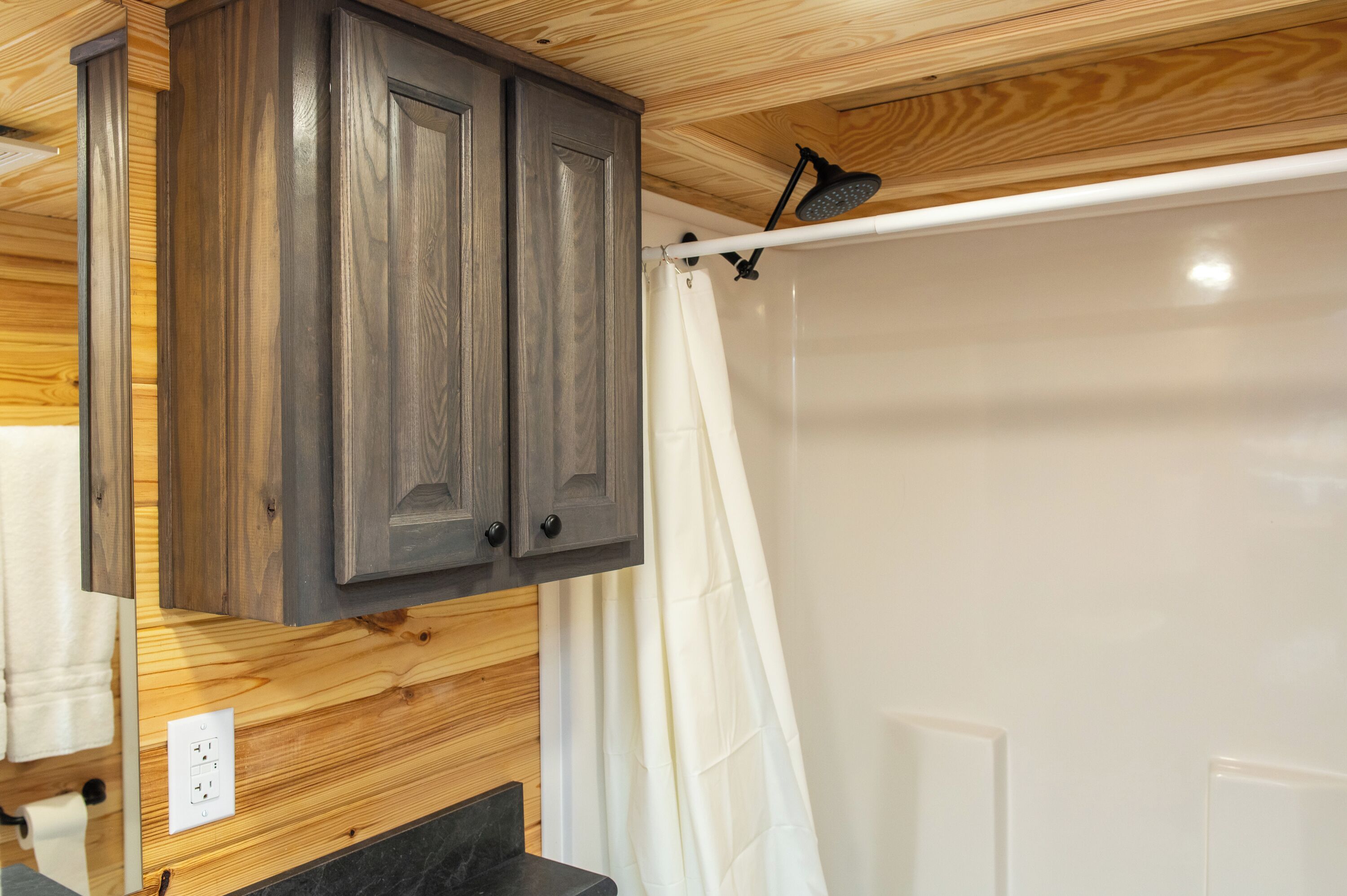 A wooden ceiling with a shower curtain rod and a shower curtain.