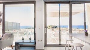 A modern living room with a large sliding glass door leading to a balcony with outdoor seating. - Starlight Villa Tropea - 4bd, 4ba, 4min To Beach (Rethymno)