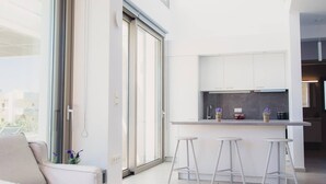 A modern kitchen with a bar area, large windows, and a minimalist interior. - Starlight Villa Tropea - 4bd, 4ba, 4min To Beach (Rethymno)