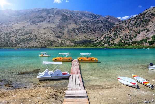 A wooden pier leading to a calm lake with clear water, surrounded by mountains. - Villa Ostria Near Georgioupolis - 5BD 4BA 10pl (Apokoronas)