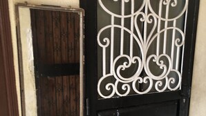 Een zwarte deur met een decoratief metalen rooster.