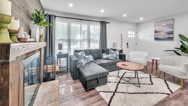 A modern living room with a sectional sofa, a coffee table, and a fireplace. - Modern Luxury Amenities Near Woodfield Mall 2 Bedroom Home by RedAwning (Rolling Meadows)