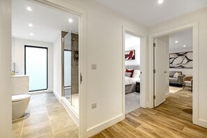 Un interior moderno con baño, ducha y sala de estar con sofá y mesa de centro.