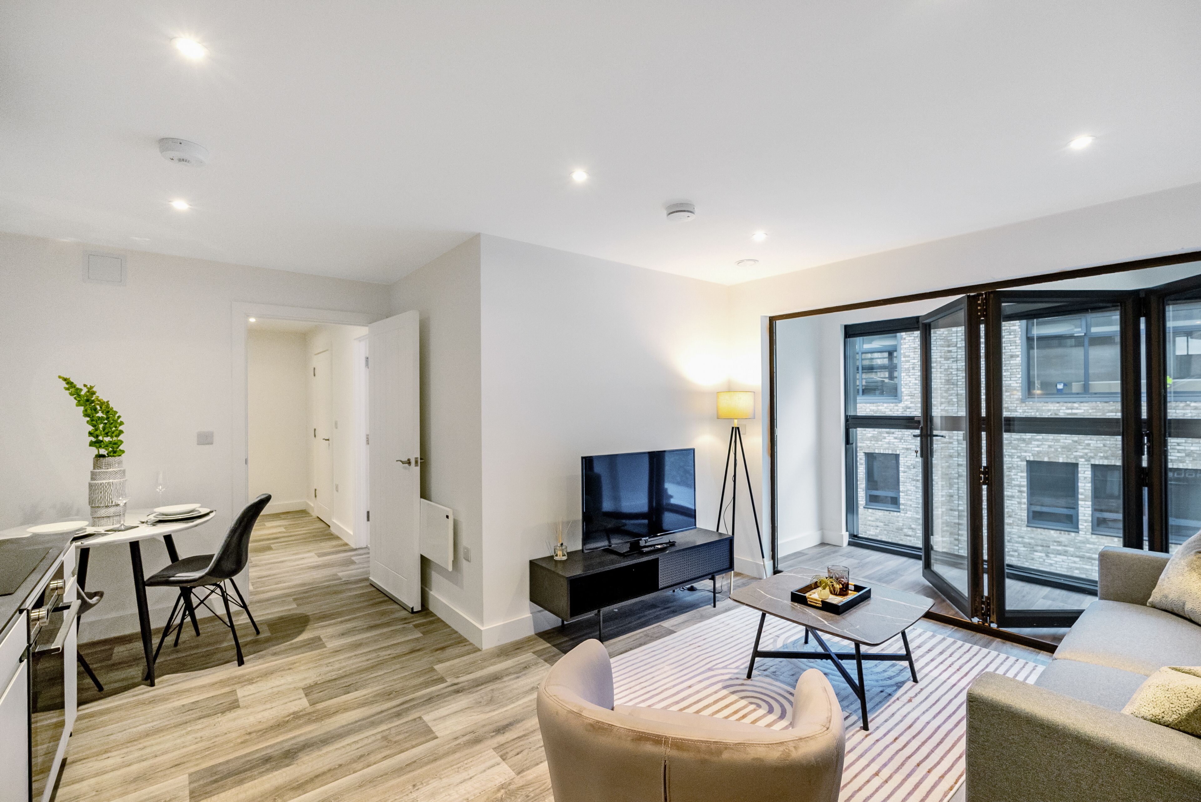 Un salon moderne comprenant un canapé, une table basse, un téléviseur et un coin repas avec une table et des chaises.