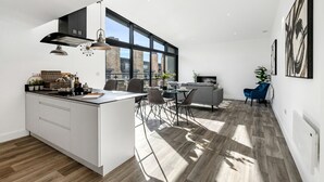 Eine moderne Küche mit einer großen Kochinsel, einem Essbereich mit Stühlen und einer Couch.
