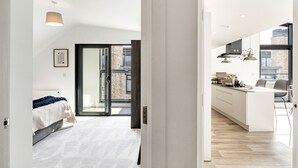Ein modernes Apartment mit Schlafzimmer, Küche und Balkon.