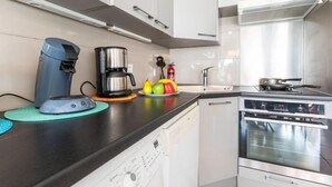 A modern kitchen with a coffee maker, a kettle, and a stove. - Isle Catherine by Interhome (Port Camargue)