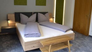 A modern bedroom with a wooden bed, two bedside tables with lamps, and a green accent wall. - Apart Hof Achenrainer by Interhome (Landeck)