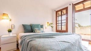 A bedroom with a bed, bedside tables, a window, and a view of the outdoors. - Paraiso by Interhome (Deltebre)