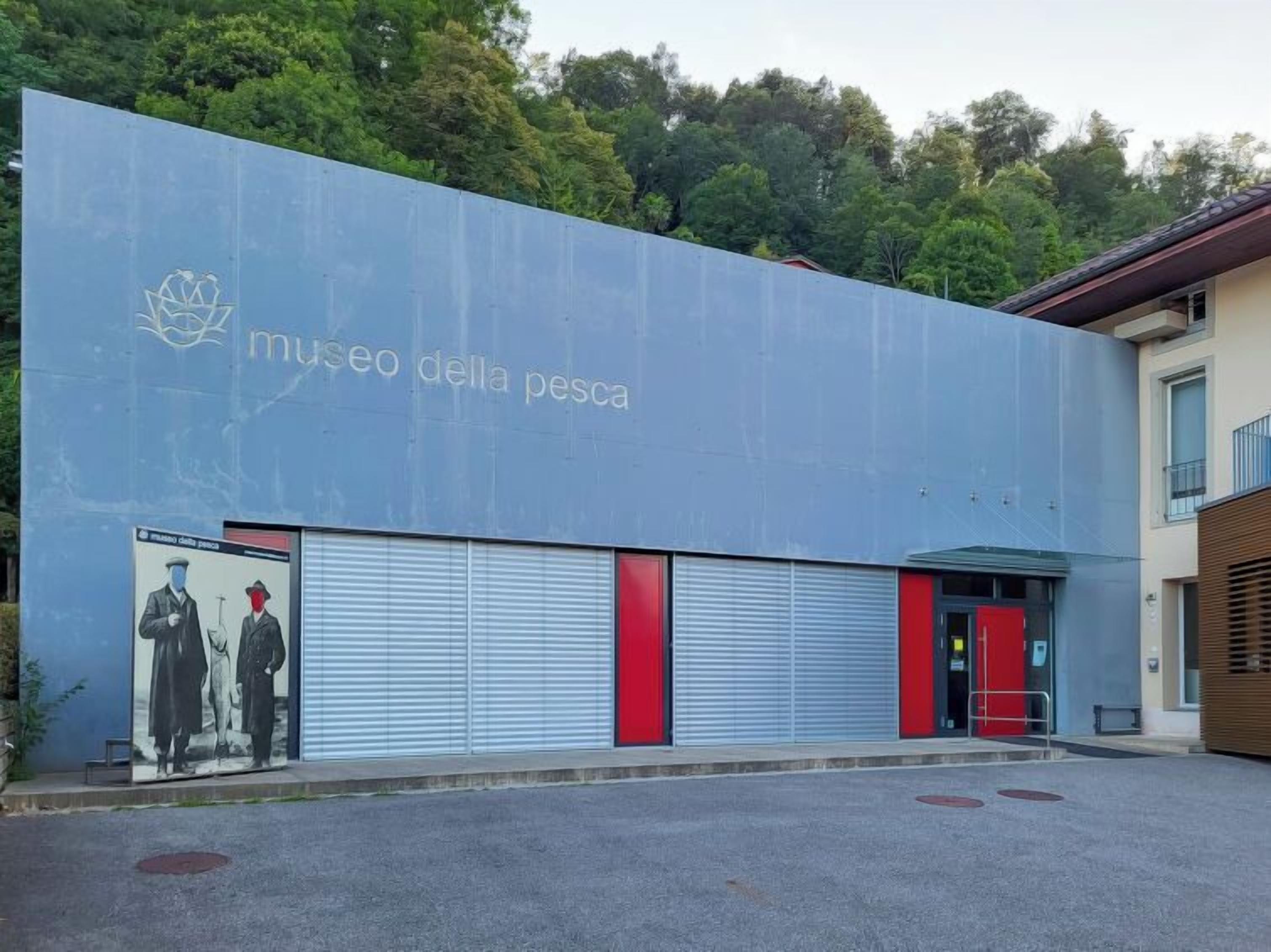 A building with a sign reading "museo della pesca" and a mural of two men.