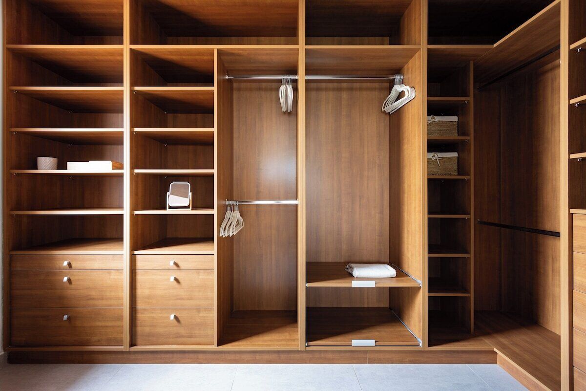 A spacious walk-in closet with multiple shelves, drawers, and hanging space.