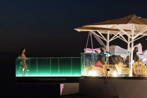 An outdoor seating area with a glass partition and a covered section with wicker chairs. - Home2Book Villa Alessandro, Design & Comfort (El Sauzal)