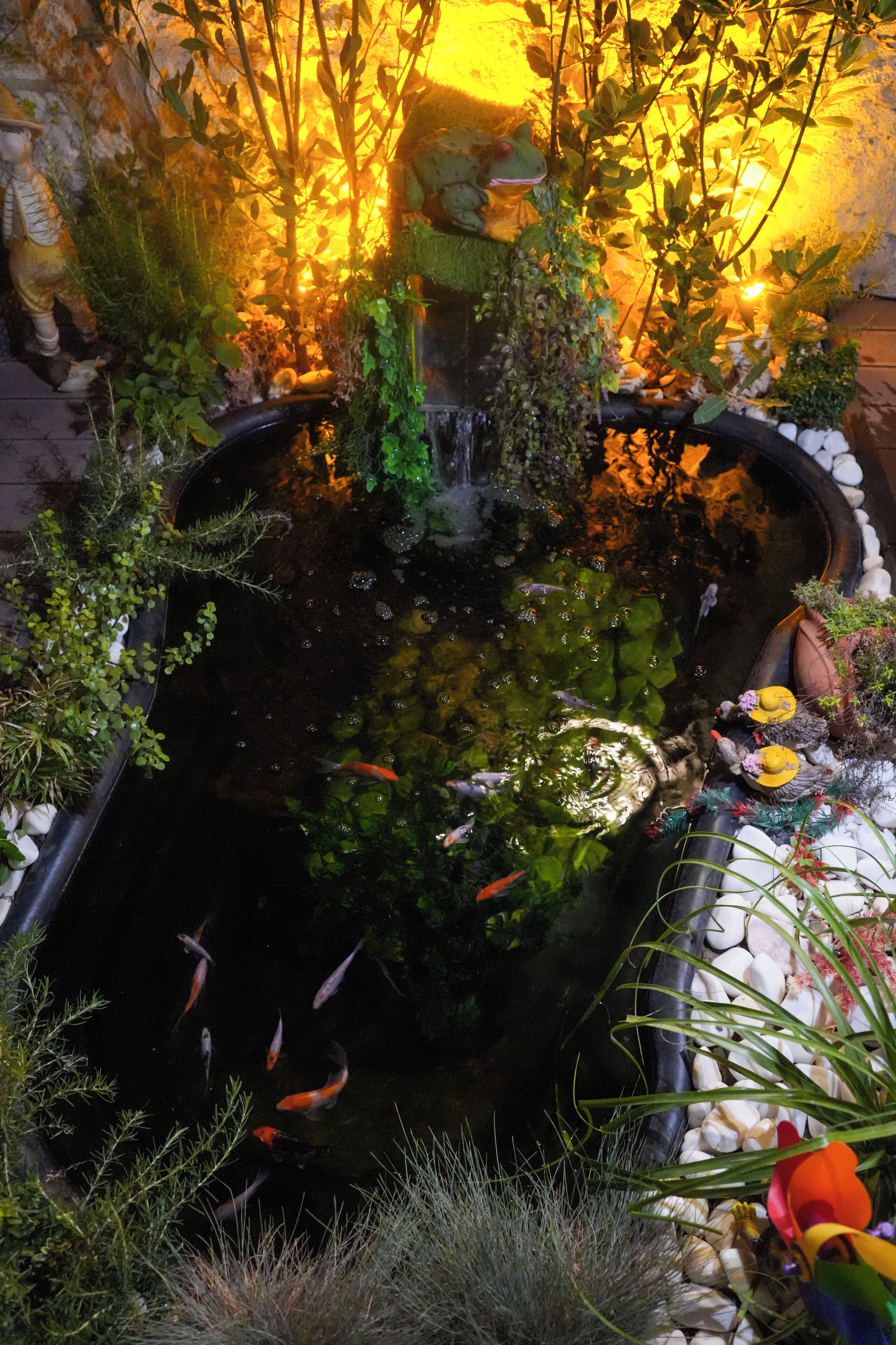 A koi pond with fish, surrounded by plants and decorative elements.
