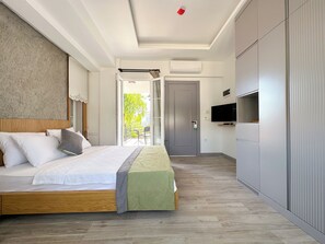 Deluxe kamer | Een minibar, een kluis op de kamer, beddengoed