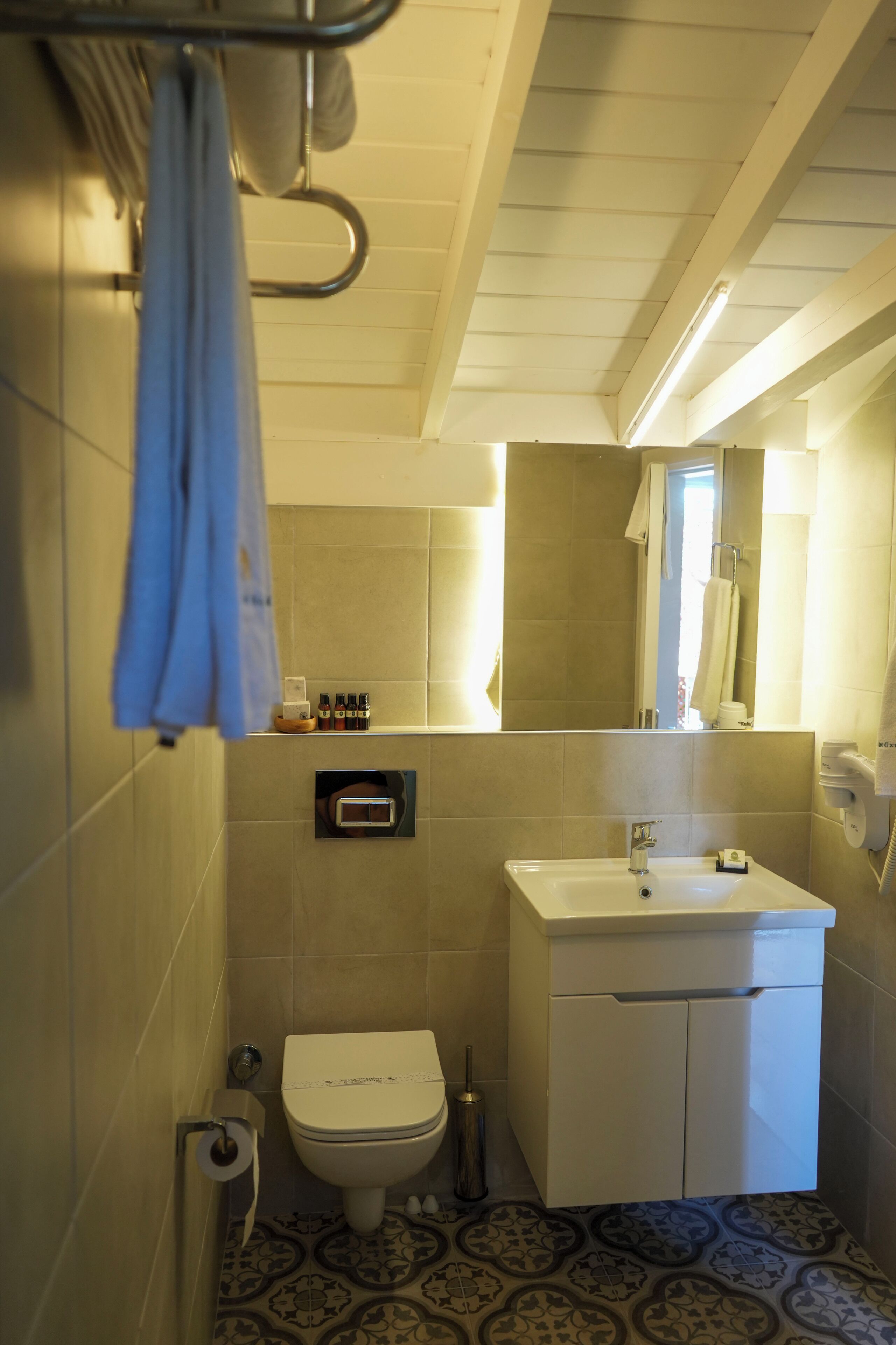 Une salle de bain avec des toilettes, un lavabo et un miroir.