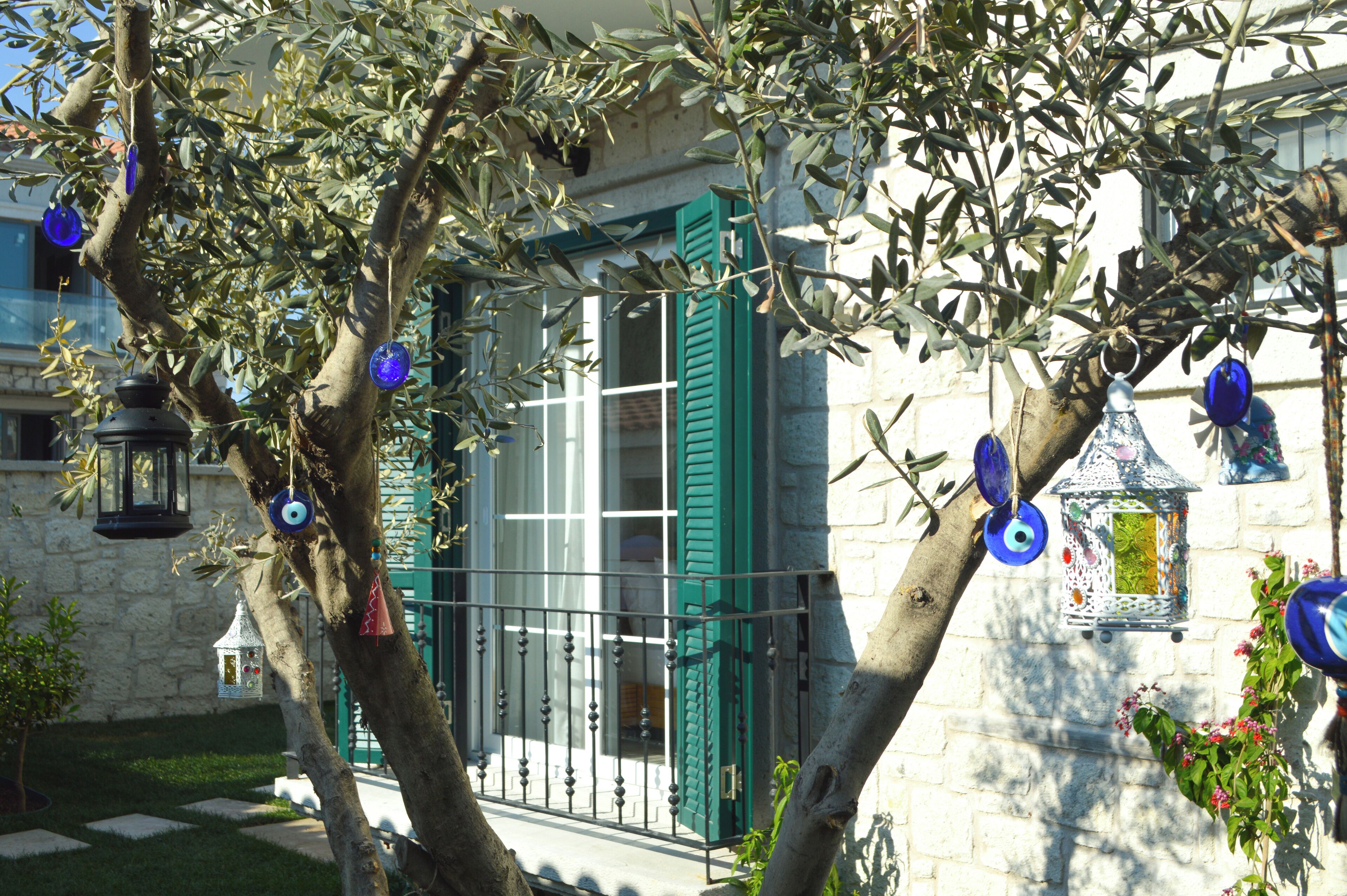 A building with a stone facade, green shutters, and decorative lanterns.
