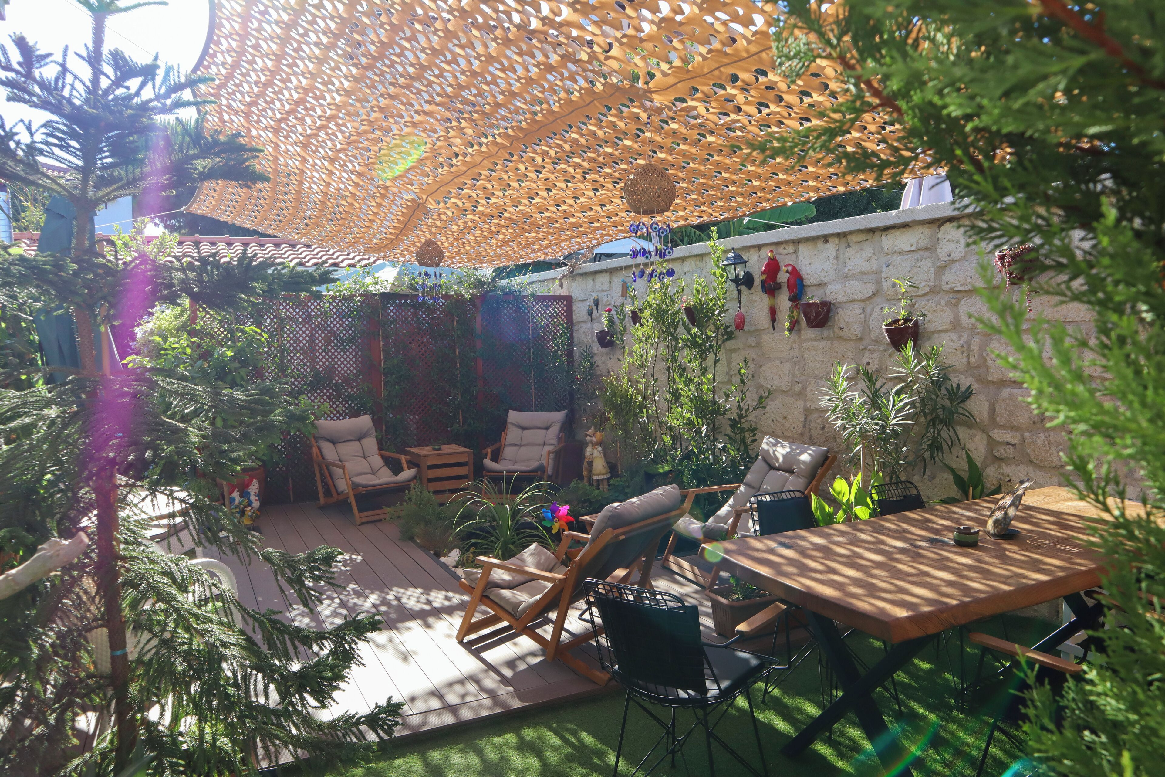 Un patio al aire libre con muebles de madera, una mesa y plantas en macetas.
