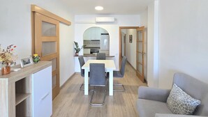 Kompakti oleskelutila, jossa on ruokailualue, pieni keittiö ja sohva.