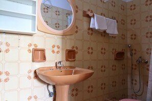 A bathroom with a sink, mirror, towel rack, and shower. - Seaview - Selfcatering Apartment - Helen No 1 (North Kynouria)