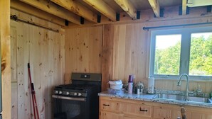 Una cucina in legno con un fornello, un lavello e degli armadietti.