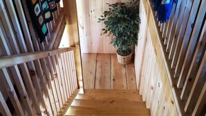 Una scala in legno con una pianta in un cesto all'inizio del pianerottolo.