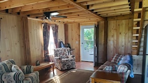 Un interno in legno con un divano, una poltrona e un tavolo.