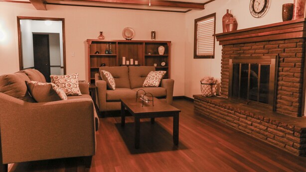 A living room with a fireplace, wooden flooring, and a bookshelf. - Quiet, 4-bed home with a park view. (Clarksville)