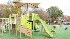 A playground with a slide, climbing structures, and a canopy. - Quiet, 4-bed home with a park view. (Clarksville)