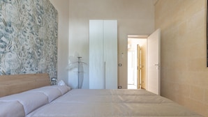 Une chambre à coucher avec un grand lit, une armoire et une lampe.