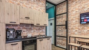 A modern kitchen with wooden cabinets, a coffee machine, and a built-in oven. - Gravina8 (Naples)