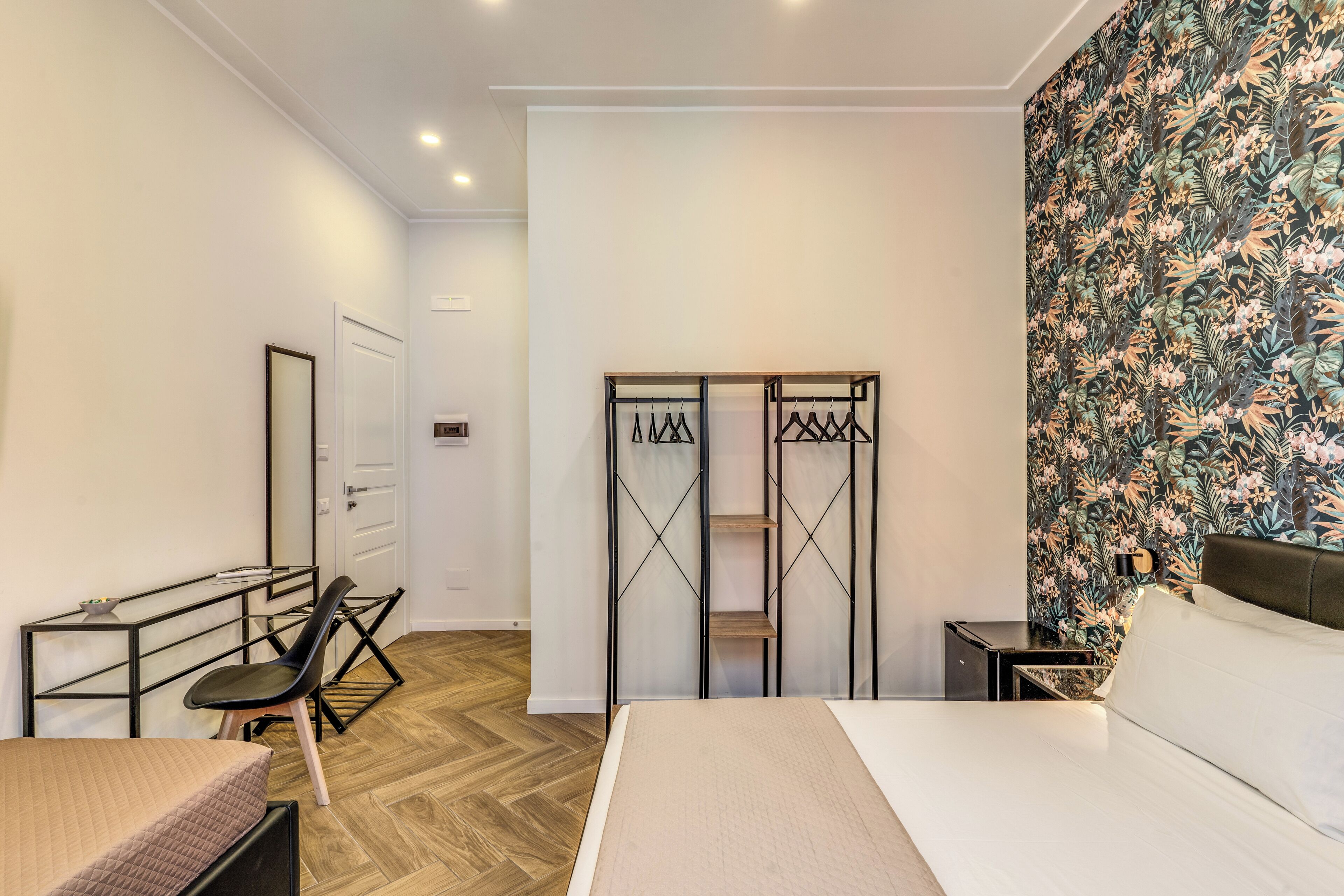 Une chambre d’hôtel comprenant un lit, un bureau, une chaise, une armoire et une table de chevet.