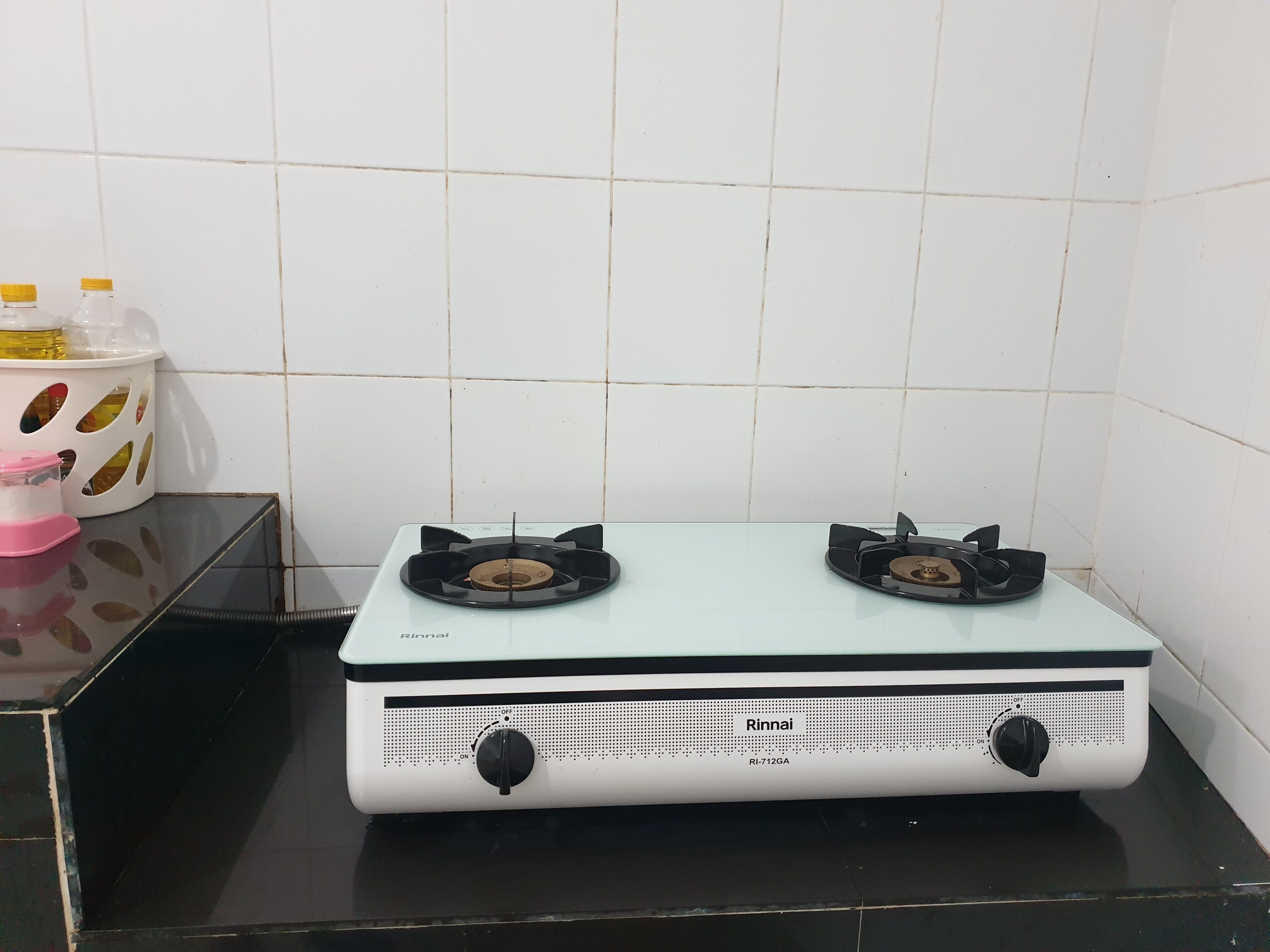 A kitchen with a white gas stove and a black countertop.