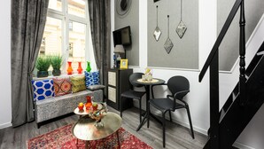 A modern living room with a sofa, a small round table, and a TV. - Native Apartments Studencka 25 (Kraków)